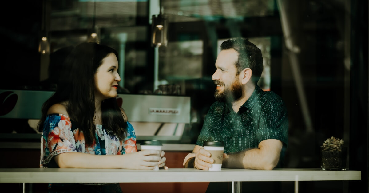 a man and woman talking over coffee