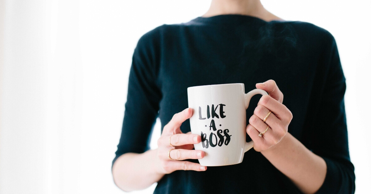 woman holding a mug which says "like a boss" on it