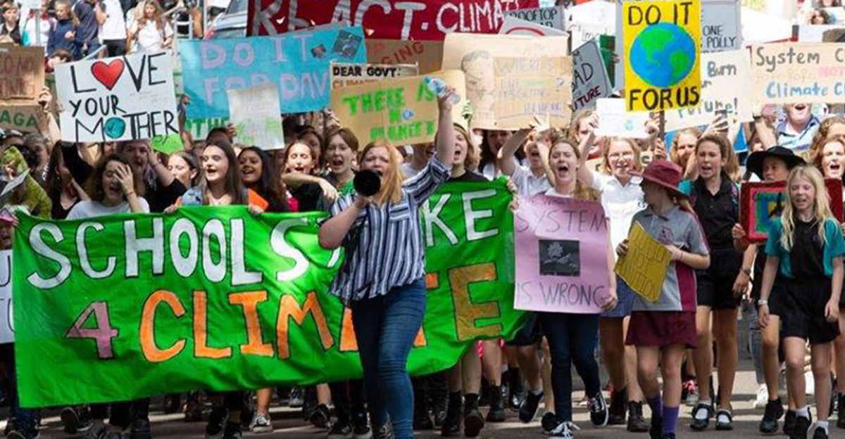 Students with signs and banners rallying in a group marching and shouting