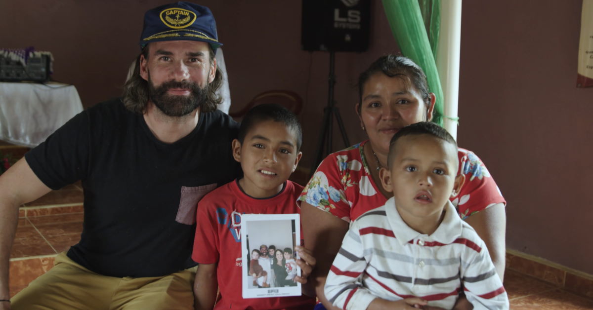 Rend Collective Band Member Gareth sitting with sponsor child and his family