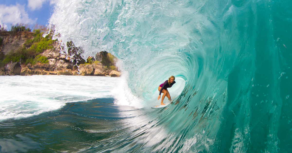 bethany hamilton riding a surfboard inside the curve of a wave