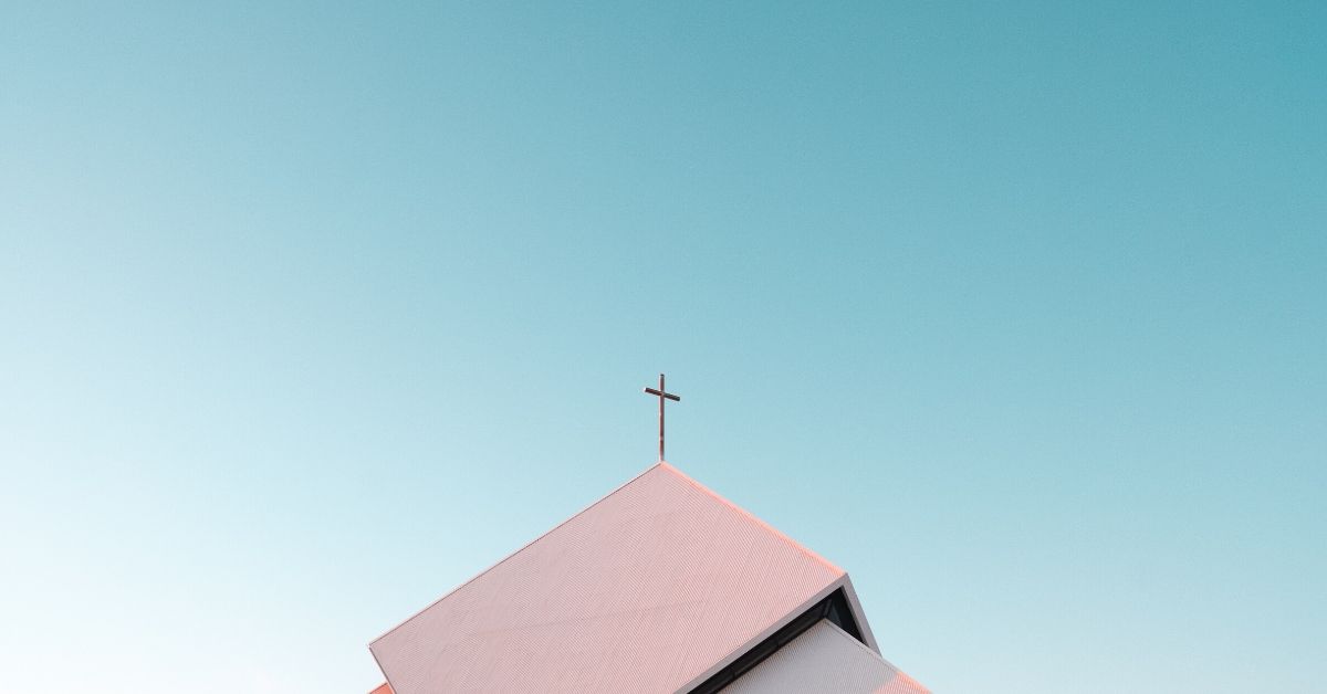 a photo of a cross on top of the roof of a church