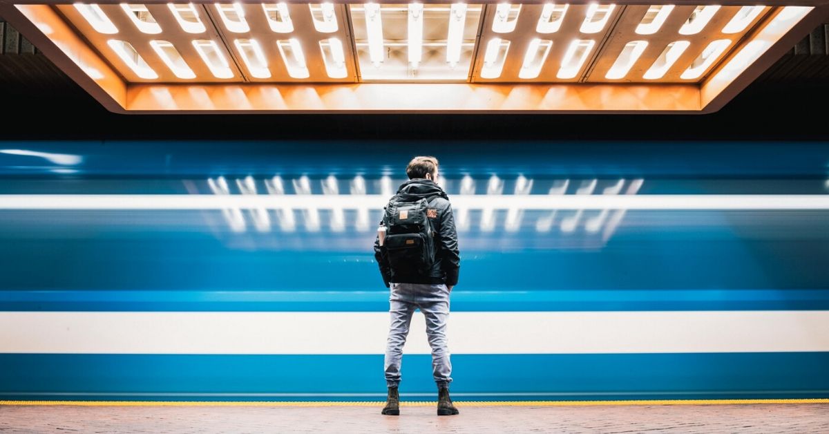 photo of a man standing in a brightly lit subway tunnel