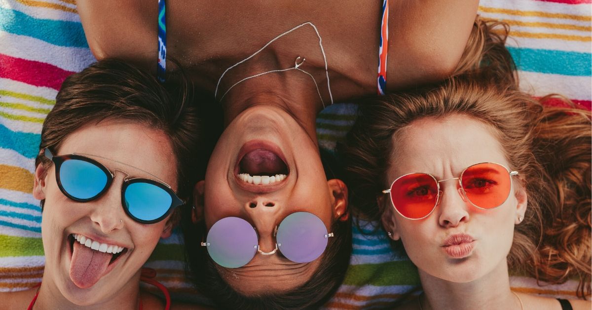 photo of 3 girls wearing colourful sunglasses