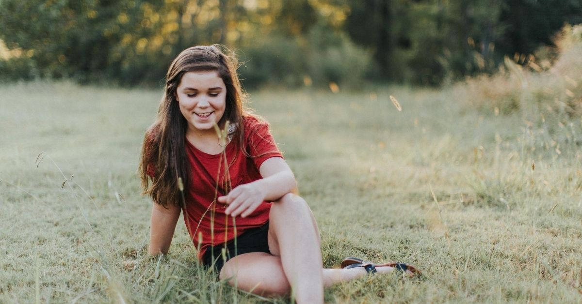 teen girl sitting in the grass
