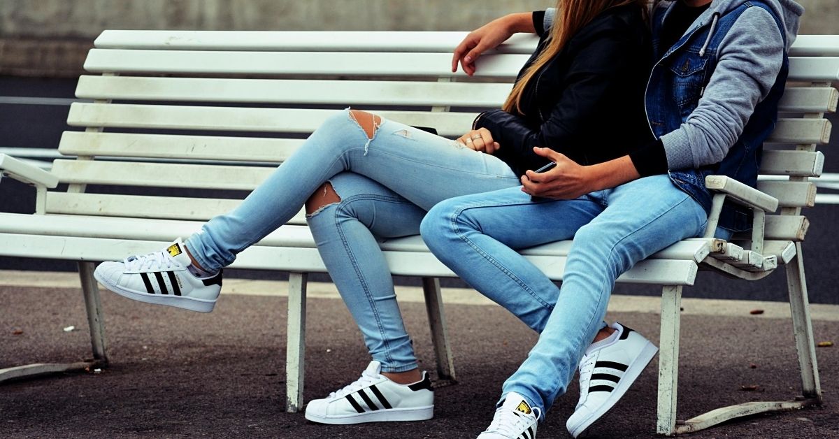 boy and girl sitting on a bench in matching outfits