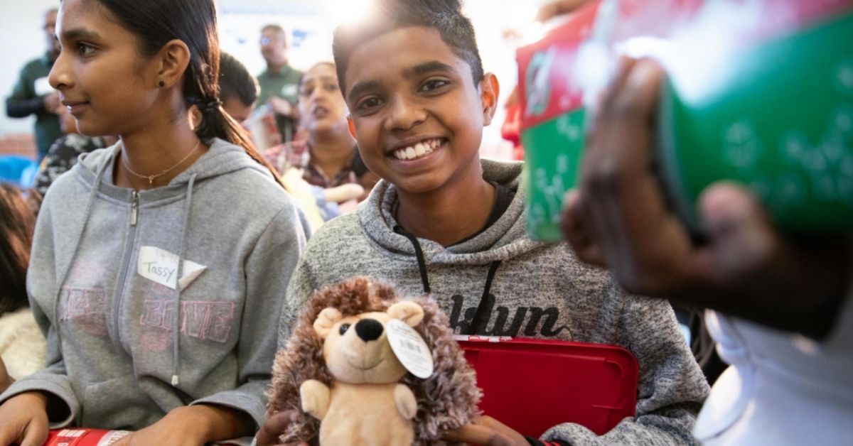 smiling children holding shoeboxes filled with gifts