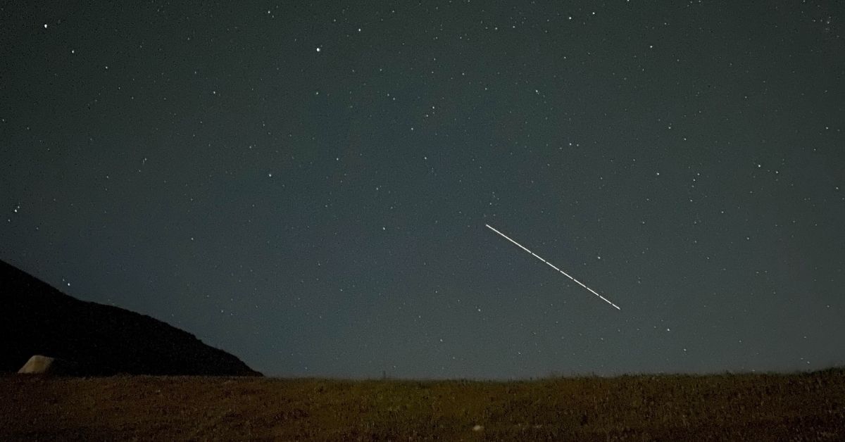 shooting star on a dark night over a field