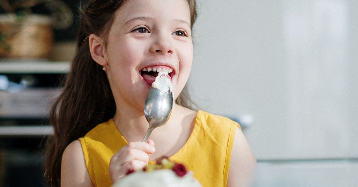 girl smiling licking a spoon
