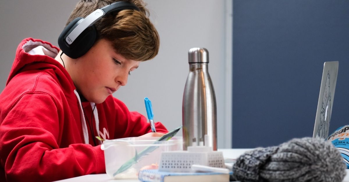 boy wearing headphones studying