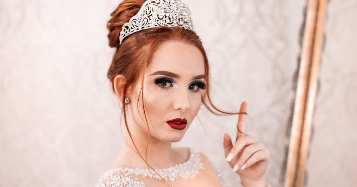 girl wearing a tiara twirling her hair