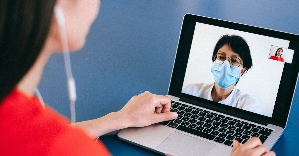 a woman video chats with a doctor on her computer