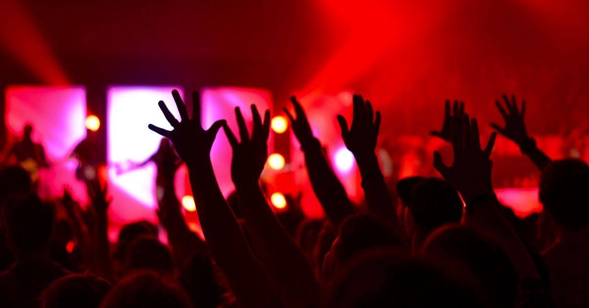 people with hands raised in worship during a church service