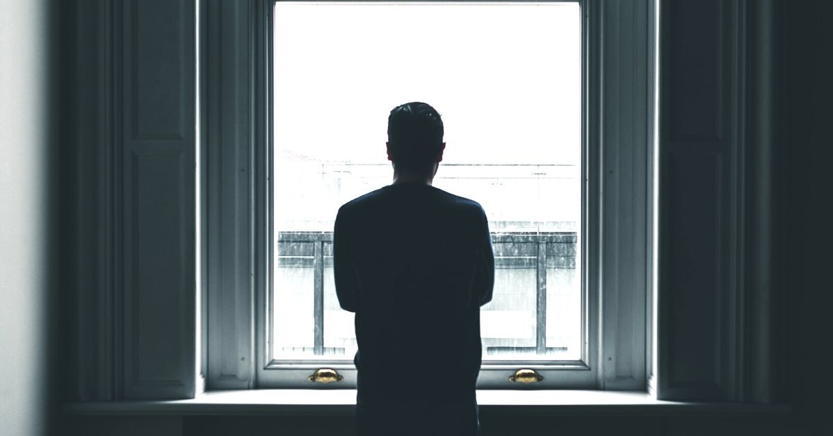 Man looking out window